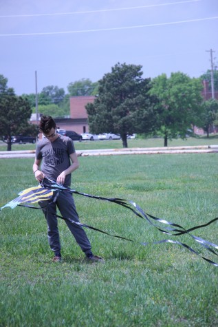 Senior Ian Gaza releases the tail ribbons of a kite. 