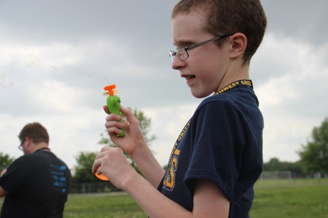 Freshman Taylor Parsons holds a bubble-blowing toy while watching others fly kites. 
