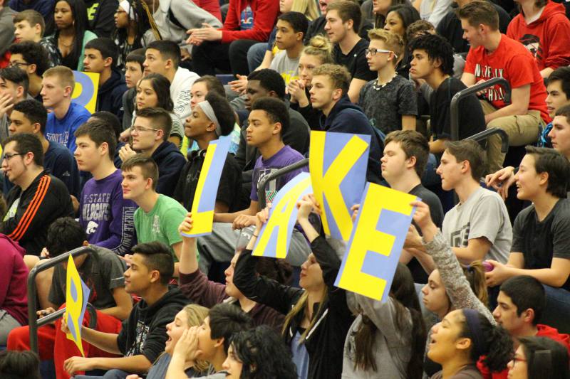 Students watch intensely, while cheering on Blake. 