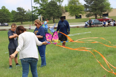 Sophomore Blake Unrein and government teacher Lori Wallentine gather string while senior Sarena Leyba holds the kite. 