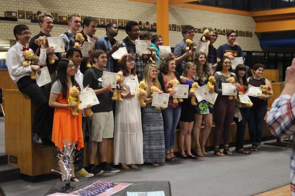 Senior orchestra and band members stand together after accepting their awards