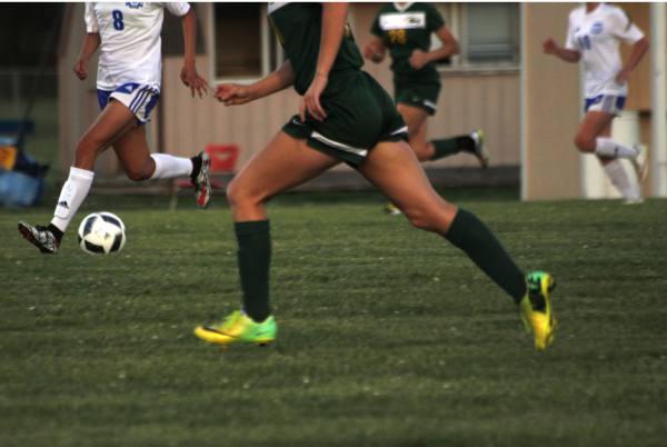 Bishop Carroll junior, Whitney Bockover, and Northwest sophomore, Abril Lucio, race to kick the ball at the Varsity soccer game on Tuesday. 