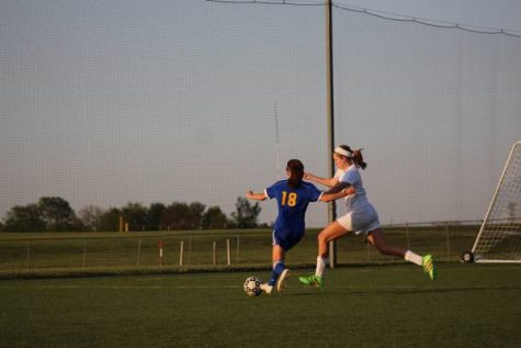 Freshman Brittan Murray races around Washburn defender to cross the ball. She is one of the few freshman to make varsity as a freshman. "Im happy to be playing along side some of the best girls in the city," said Murray. 