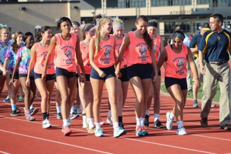 The women's varsity volleyball team make lead on the march with the JV and freshman teams following behind them.