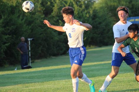 Junior Bryce Harman gets back the ball as Senior Tyler Fisher defends against a Derby player.