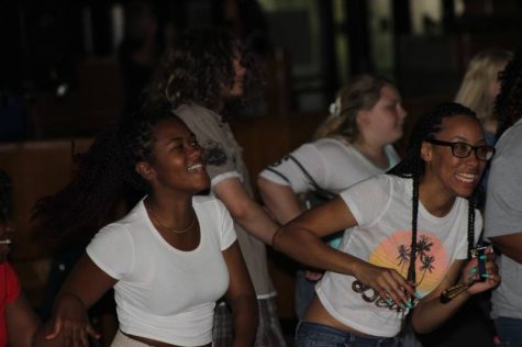 Junior Dawn Loggins and Junior Daja Burch dancing in the commons to the music.