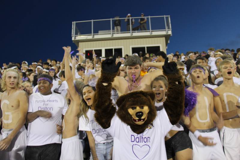 Senior students cheering for their team in the front of the stands.