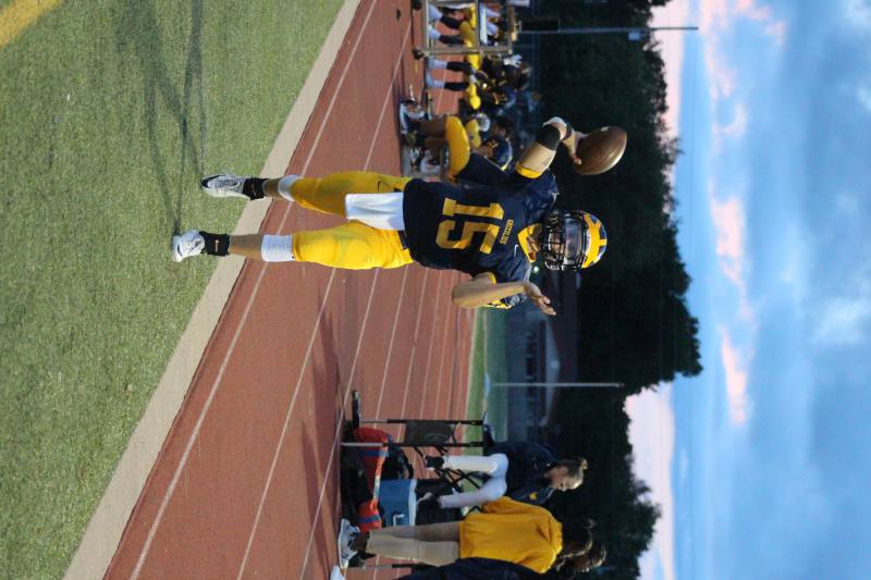 Junior Austin Anderson warms up on the sidelines while passing the ball.