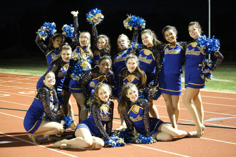 The dance team poses for a group photo on the track.