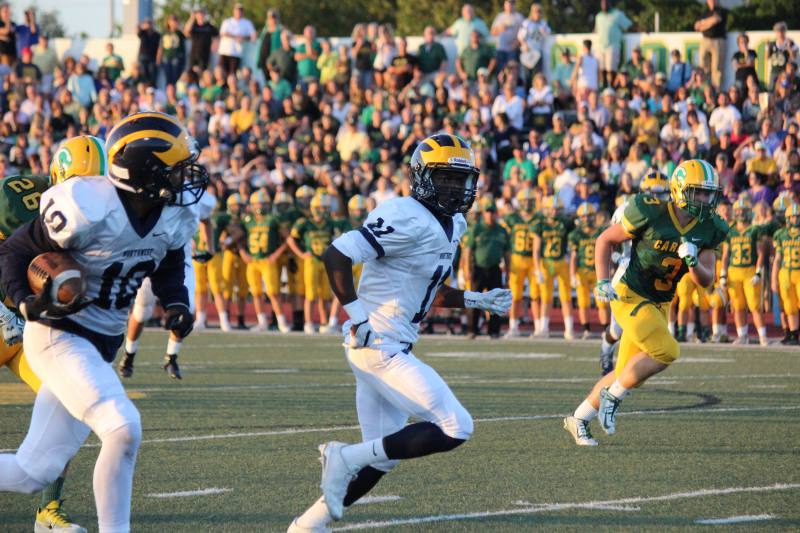 Junior Jaxson Reynolds carries the ball as Senior Martese Mullins runs beside him.