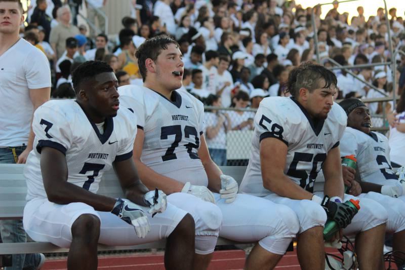 Junior Jalen Smith and Seniors Joey Gilbertson and Angel Washee sit on the bench watching their teammates play.