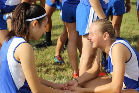 Freshman Joy Stanton and Sophomore Tadum Soetaert hold hands and pray before the meet.