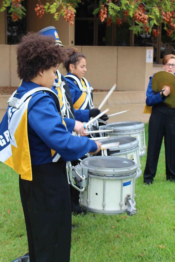 Percussionists play the snare drums with senior, Karsen Ross outside of Century II.
