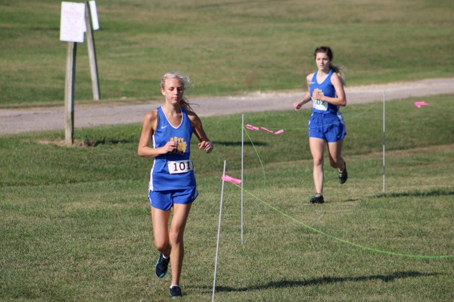 Coming around a curve, senior Kylie Mouser and junior Sydnee Gardner lead the runners at the cross country meet on Sept. 29. Mouser won the event with a time of 23:39:81.