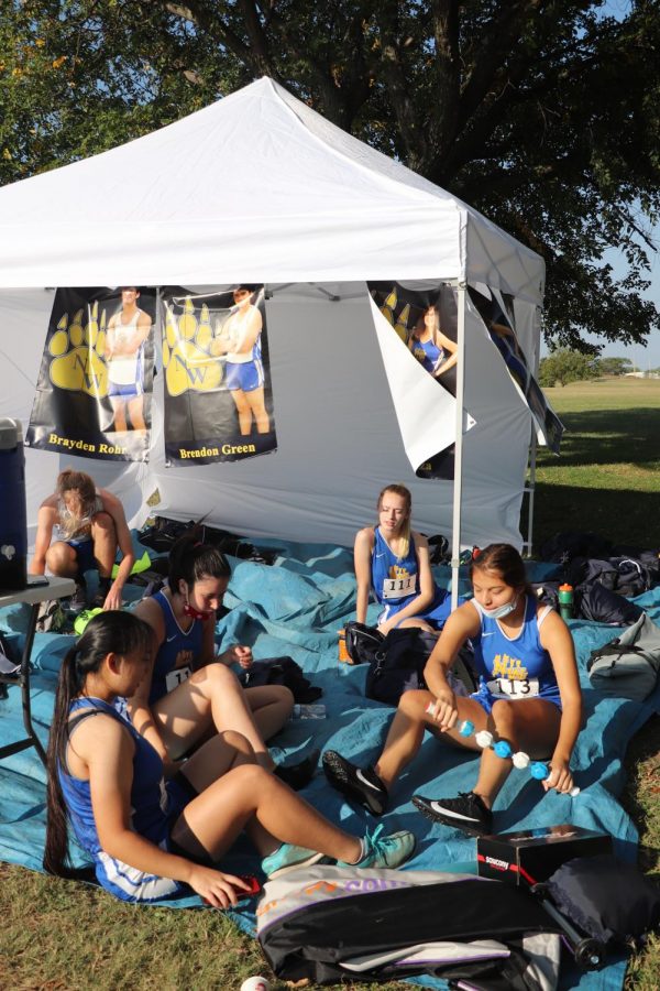 Members of the girls team relax and get loose before their run at the Cessna Activity Center on Sept. 29. 