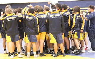 The wrestling team doing their chant, getting ready to compete. 