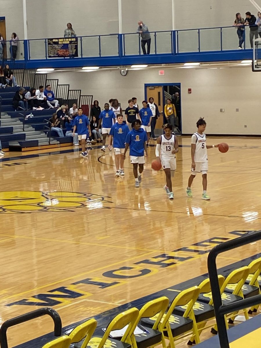 Boys basketball team official walking out to start the game.